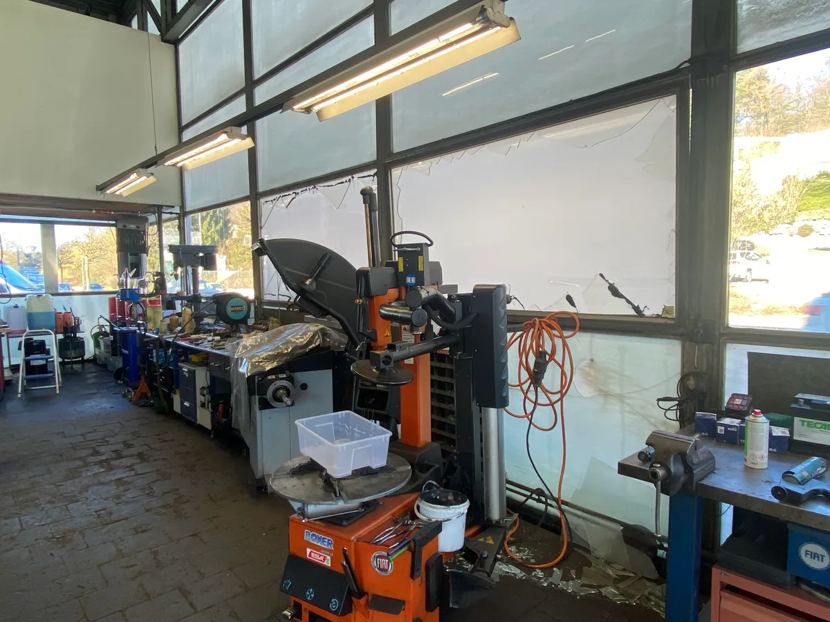 Zerborstene Fensterscheiben nach der heftigen Detonation in Illnau. Man sieht die Werkstatt des Auto Centers Illnau, wo kaputte Scheiben behelfsmässig abgeklebt wurden.